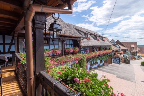 un bâtiment avec des fleurs sur son côté dans l'établissement Hotel Kieffer, à Itterswiller