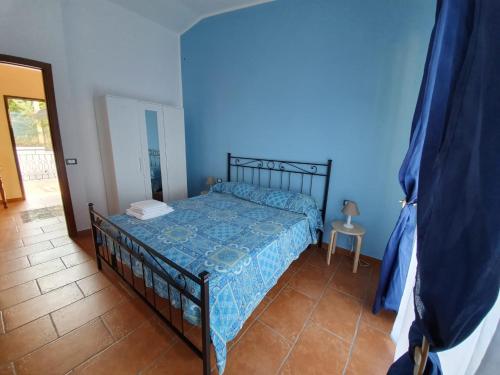 a bedroom with a bed in a blue room at L'Opuntia sul lago in Caccamo