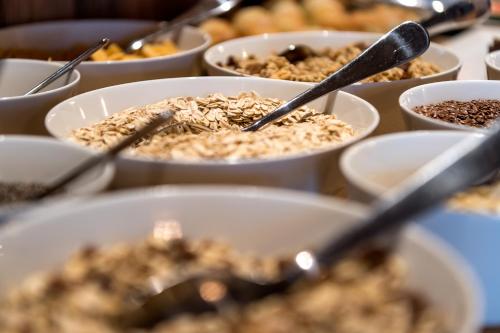 a table topped with bowls of food with spoons at Chalet Cogolara in Colfosco