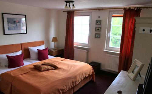 ein Schlafzimmer mit einem Bett und zwei Fenstern in der Unterkunft Kapitänshaus in Strandnähe in Prerow in Prerow