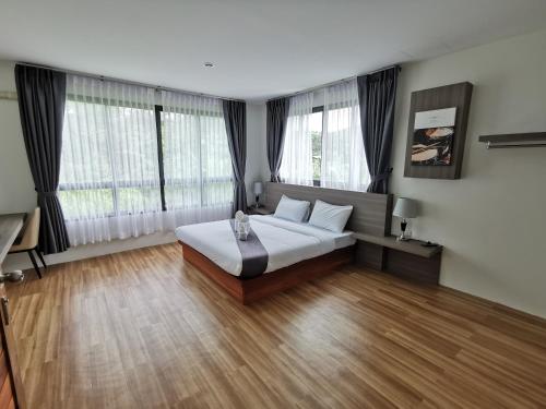 a bedroom with a bed and two windows at Nana Beach Hotel & Resort in Pathiu