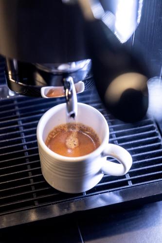 a cup of coffee is being brewed in a coffee machine at Chalet Cogolara in Colfosco