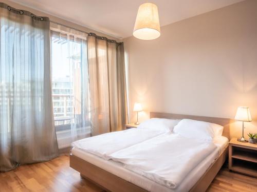 a bedroom with a large bed and a large window at VacationClub – Olympic Park Apartament A503 in Kołobrzeg