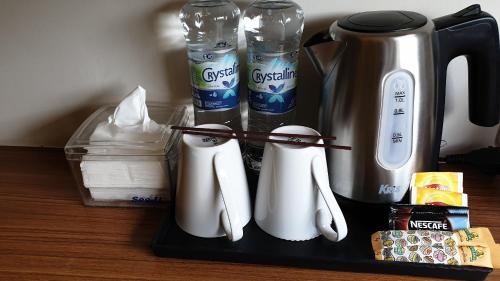 a tray with a coffee maker and utensils on a table at BIZ HOTEL City Center in Ambon