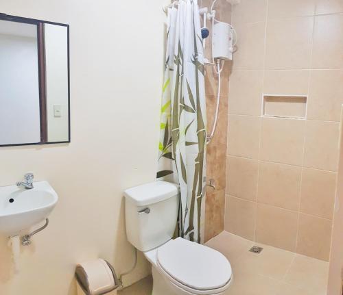 ein Bad mit einem WC, einem Waschbecken und einer Dusche in der Unterkunft North Tourist Inn in Bacolod City
