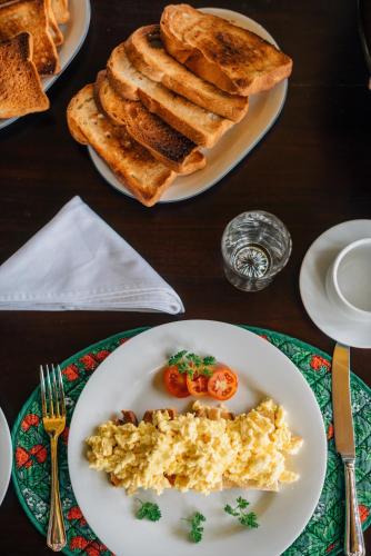 Una mesa cubierta con platos de comida con tostadas. en SinhaGiri Mansion, en Nuwara Eliya