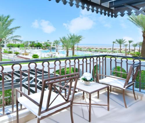a balcony with chairs and a view of the pool at Steigenberger Alcazar in Sharm El Sheikh