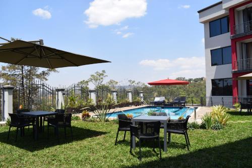 eine Terrasse mit Tischen und Stühlen und einem Pool in der Unterkunft Mythos Boutique Hotel in Kigali