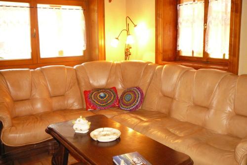 a leather couch in a living room with a table at Drevenica - Božie domčeky in Liptovská Osada