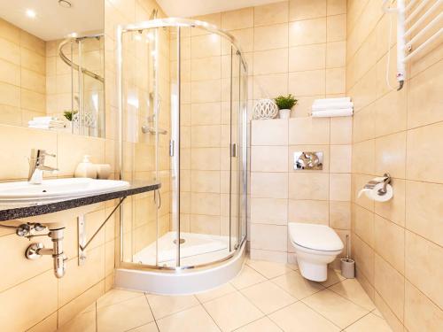 La salle de bains est pourvue d'une douche, de toilettes et d'un lavabo. dans l'établissement VacationClub – Baltic Park Plaża 22 Apartament 4.2.3., à Świnoujście