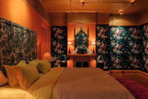 a bedroom with a large bed and floral wallpaper at SinhaGiri Mansion in Nuwara Eliya