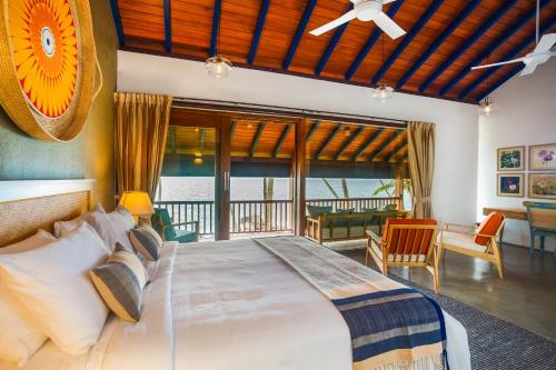 a bedroom with a large bed and a balcony at Bay Villas Balapitiya in Balapitiya