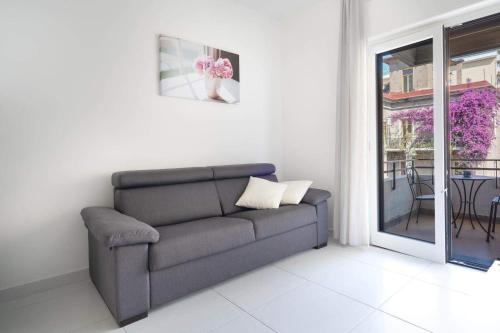 a living room with a couch and a balcony at Smiling Apartments Vico Equense in Vico Equense