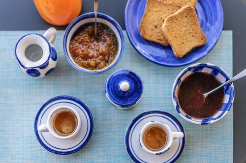 a table with cups of coffee and plates of toast at Smiling Apartments Vico Equense in Vico Equense