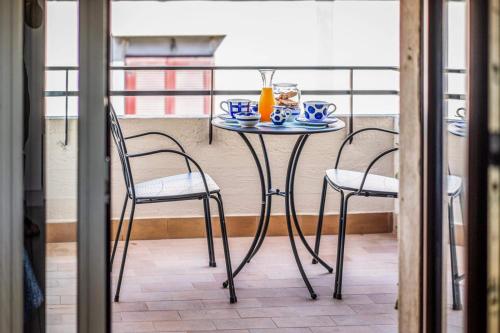 a table and two chairs on a balcony at Smiling Apartments Vico Equense in Vico Equense