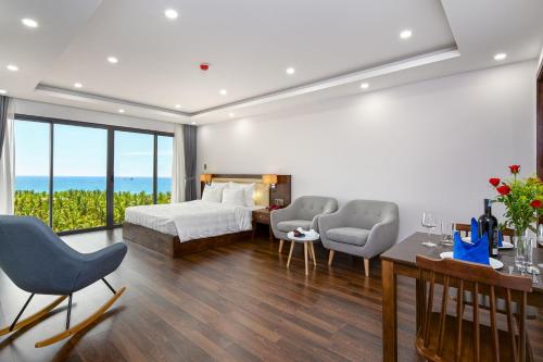 Un dormitorio con una cama y dos sillas y una mesa. en DANA RESIDENCE, en Da Nang