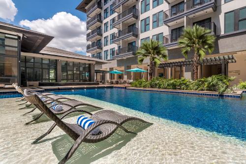 a swimming pool with lounge chairs next to a building at Dusit Thani Residence Davao in Davao City
