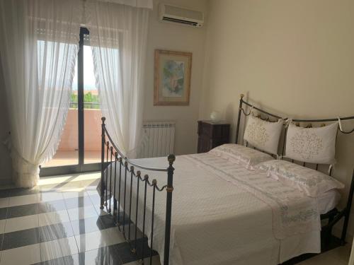 a bedroom with a bed and a large window at Gess Etna Home in Giarre