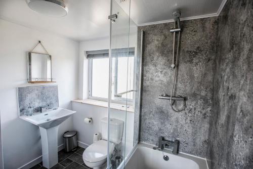 a bathroom with a shower toilet and a sink at The Sheiling in Tarbert