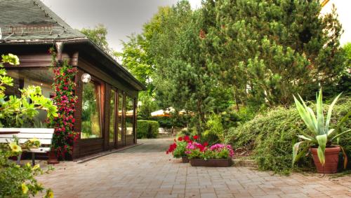 a garden with flowers and a pavilion at Ferienhotel Augustusburg in Augustusburg