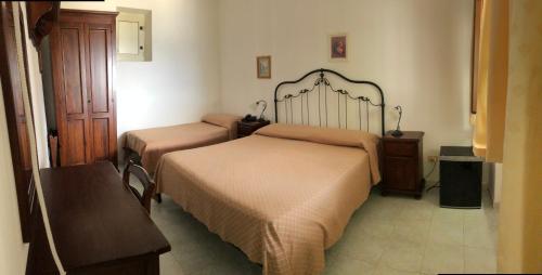a bedroom with two beds and a table and a bench at Hotel Villaggio Stromboli - isola di Stromboli in Stromboli