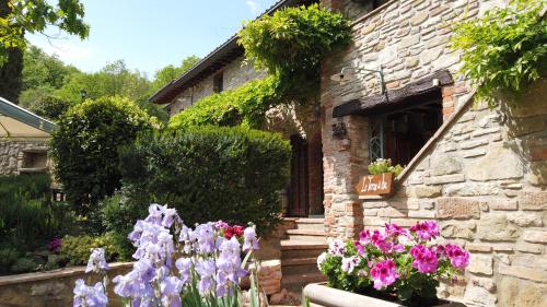 a stone house with flowers in front of it at Le Terre Di Isa in Magione