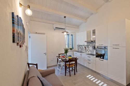 ロジニャーノ・マリッティモにあるLa Villa 31 - Locazione Turisticaのキッチン、ダイニングルーム(ソファ、テーブル付)