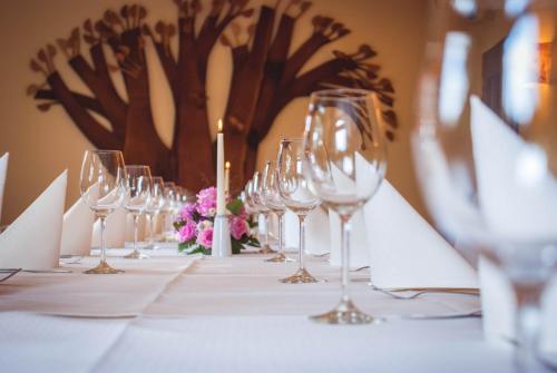 a table with wine glasses and flowers on it at Ferienhotel Augustusburg in Augustusburg