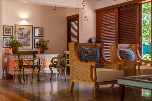 a living room with chairs and a table at Bay Villas Balapitiya in Balapitiya