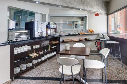 a kitchen with a table, chairs and a refrigerator at Hotel Nuevo Triunfo in Barcelona