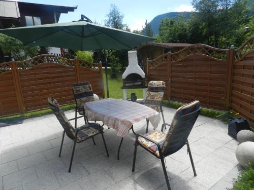 a patio with a table and chairs and an umbrella at Haus Wittig in Sankt Ulrich am Pillersee