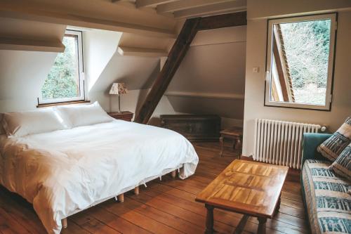 a bedroom with a bed and a table and a couch at "La Girelle, bord de mer" in Honfleur