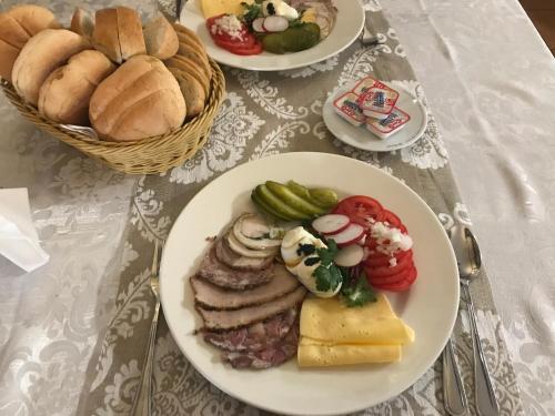 a table topped with plates of food with bread and pastries at Karczma Pod Topolami in Ratowo Piotrowo