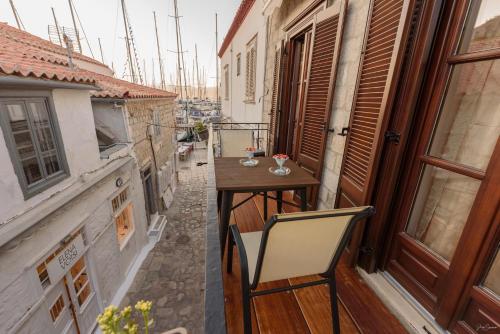 a balcony with a table and a chair at Guarda il porto in Hydra