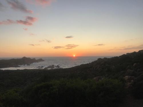 a sunset over the ocean with the sun in the distance at Sardegna Isola Rossa La Terrazza panoramiccissimo Cod iun S 8250 in Trinità dʼAgultu