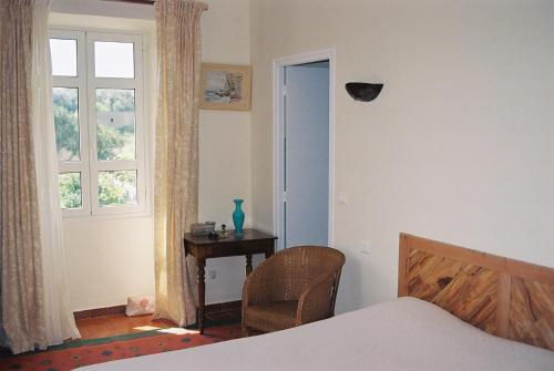 a bedroom with a bed and a table and a window at A Loghja Di Cavallo Morto in Bonifacio