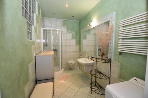 ジェロナ・グラにあるZielone Pokojeのバスルーム(バスタブ、洗面台、トイレ付)