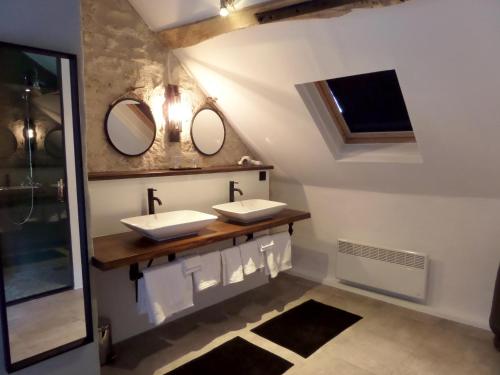 a bathroom with two sinks and two mirrors at Domaine Pouzoult, gîte l'Escalier in Sazeray