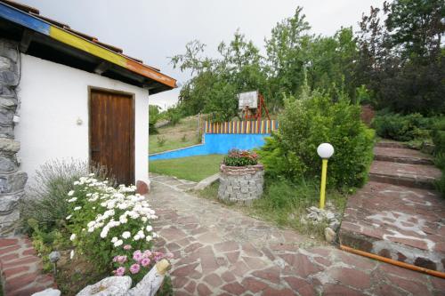 a garden with a house and a fence at Chuchi Guest House 1 in Zlatna Panega
