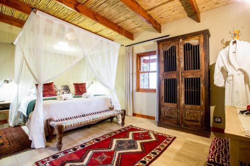 a bedroom with a bed with a canopy at De Zeekoe Guest Farm in Oudtshoorn