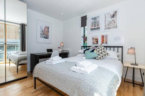 a bedroom with a bed with towels on it at Oxfordshire Living - The Lewis Apartment - Oxford in Oxford