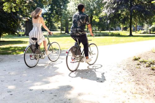 un hombre y una mujer montando bicicletas en un parque en Conscious Hotel Museum Square, en Ámsterdam