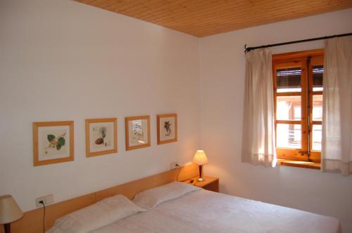 Habitación blanca con cama y ventana en Apartaments Vall Ferrera, en Àreu
