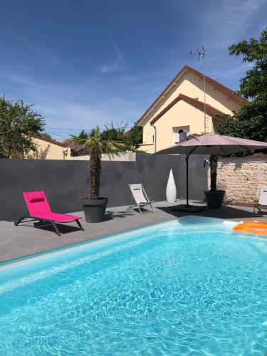 a swimming pool with a pink chair and an umbrella at Logis L'Hôtel D'Arc in Arc-sur-Tille