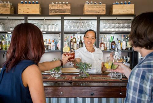 a bartender making cocktails at a bar at De Zeekoe Guest Farm in Oudtshoorn