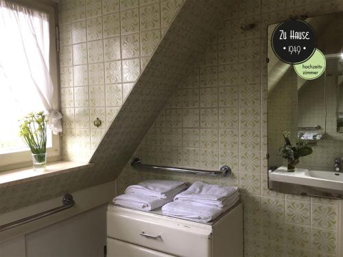 La salle de bains est pourvue d'un lavabo et d'un tas de serviettes. dans l'établissement Zu Hause 1949, à Markdorf