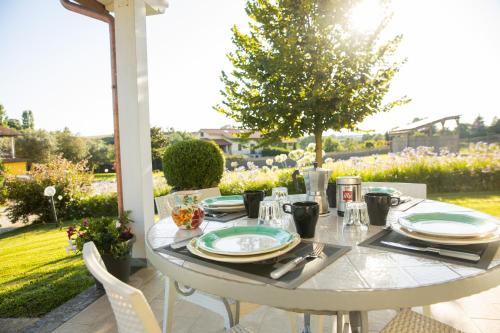 Biały stół z talerzami i przyborami kuchennymi na patio w obiekcie Villa la casa di Siro w mieście Bracciano