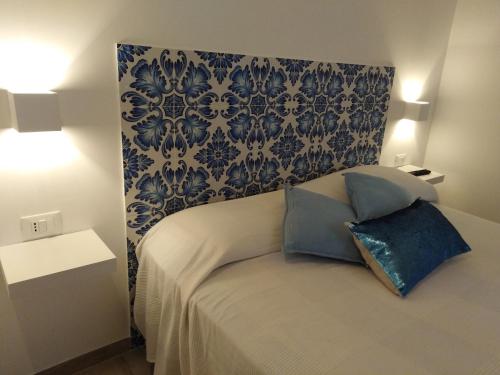 a bedroom with a bed with a blue and white wallpaper at la casetta in Favignana