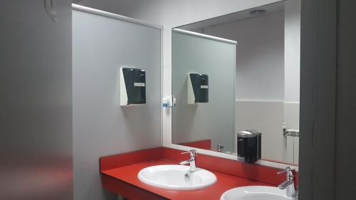 łazienka z 2 umywalkami i dużym lustrem w obiekcie Hostel Royalty ALBERGUE w mieście Santander