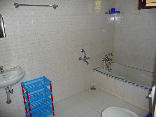 e bagno con servizi igienici, vasca e lavandino. di Ganesh Ayurveda Holiday Home Apartment a Kovalam